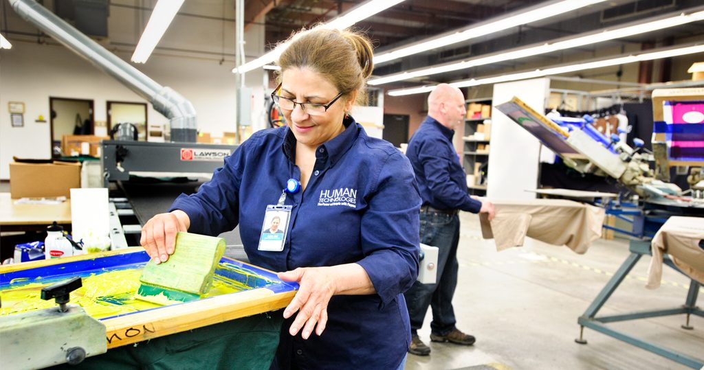 Employees screen printing t-shirts