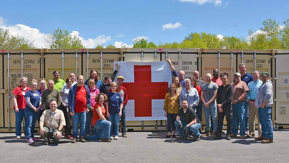 HT Employees standing in front of a row of shipping containers