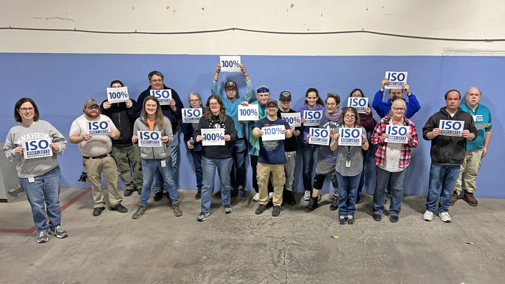 Human Technologies employees holding signs that read: 100% ISO 9001:2015